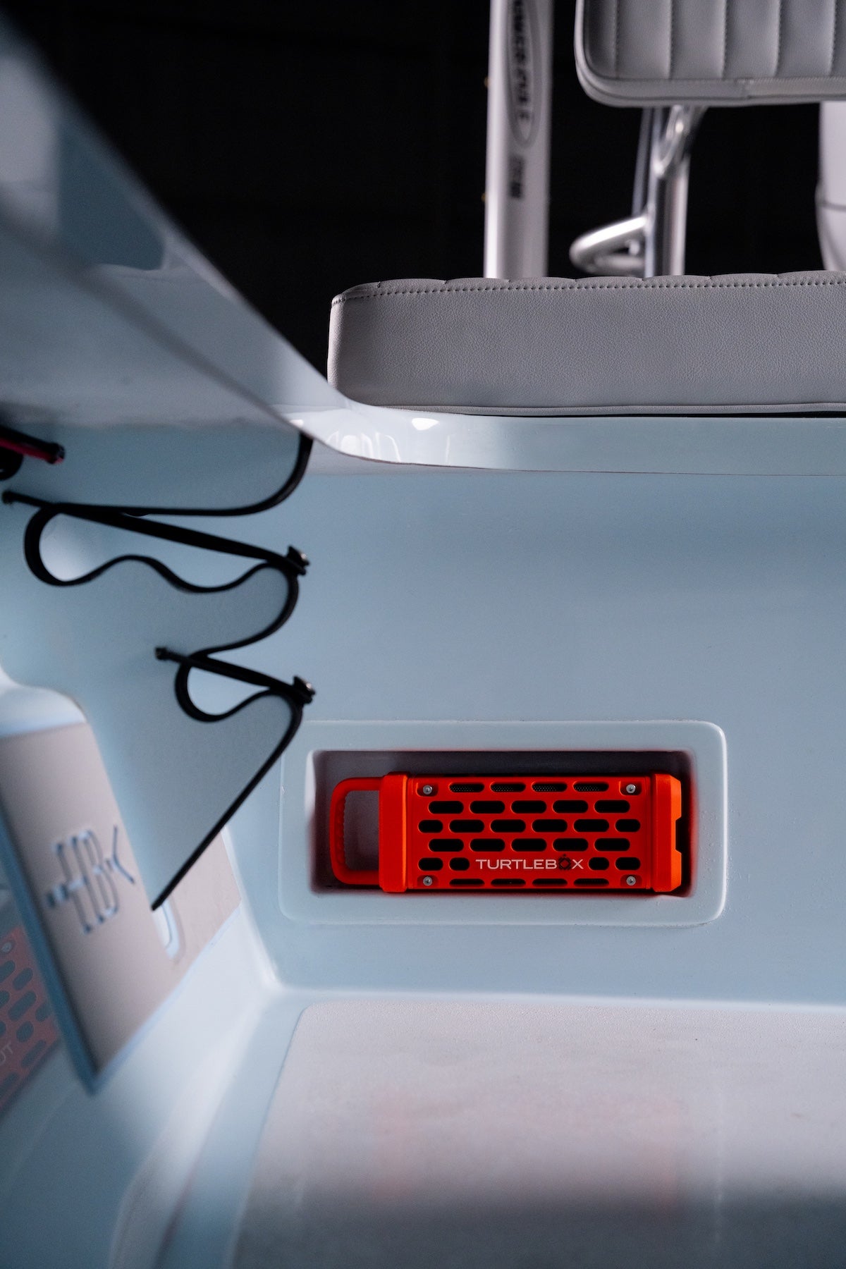 Orange Turtlebox speaker set into a recessed mount in the rear bulkhead